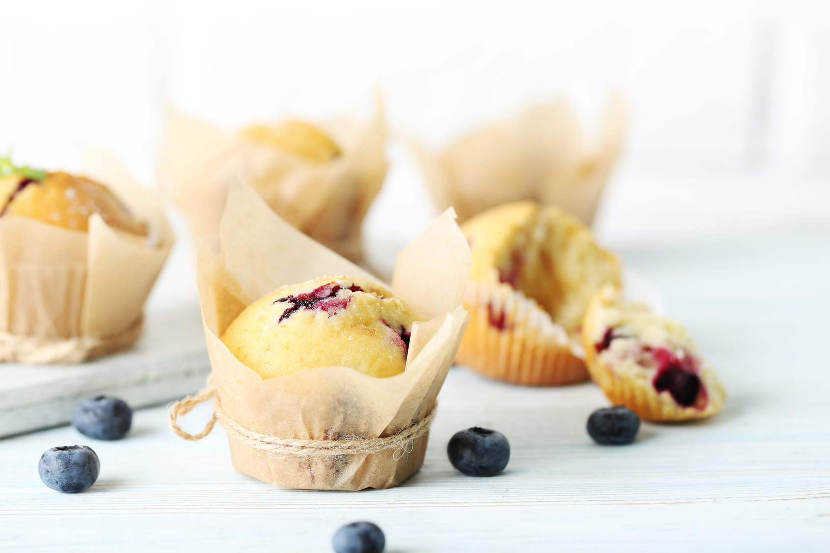 Muffins with blueberries on blue wooden table