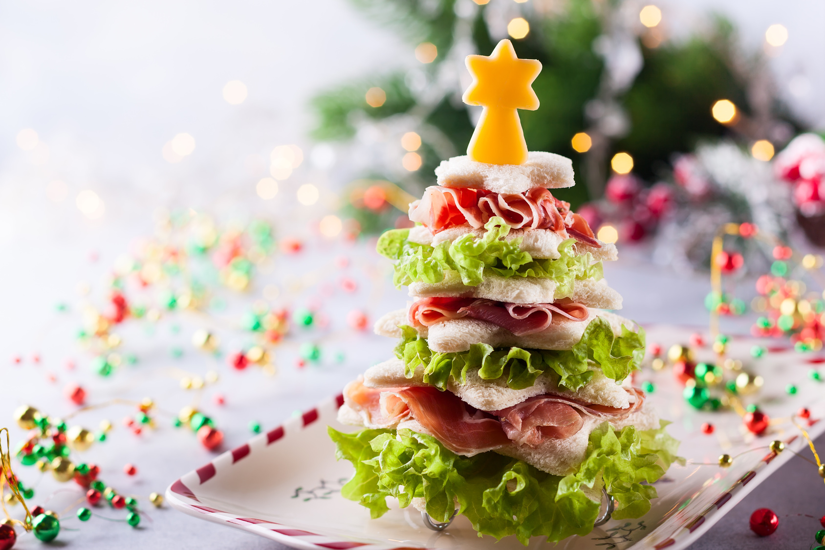 Christmas tree from toasted bread, lettuce, ham and cheese. Festive idea for Christmas or New Year dinner.